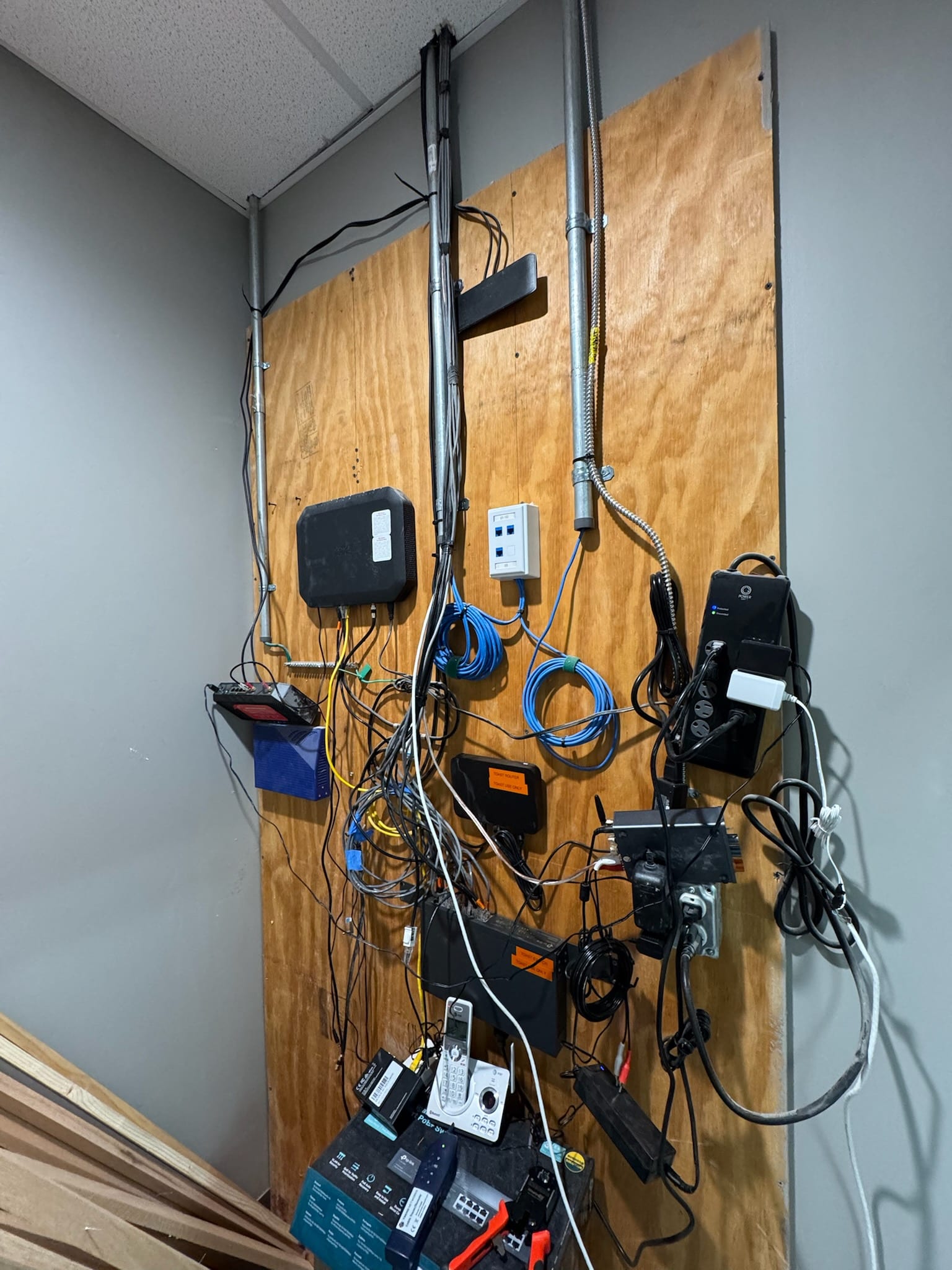 Before ICTAlly: tangled cables and equipment mounted on plywood board with no cable management at Candy Cloud in Smyrna TN